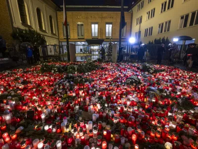 22 December 2023, Czech Republic, Prague: People light candles and place flowers at a makeshift memorial in front of the building of the Faculty of Philosophy of Charles University for the victims of the deadly shooting. On Thursday afternoon, a shooter opened fire at a university in central Prague, killing at least 14 people and injuring 25, 10 of whom were critically. Photo: Ř&iacute;hov&aacute; Michaela/CTK/dpa