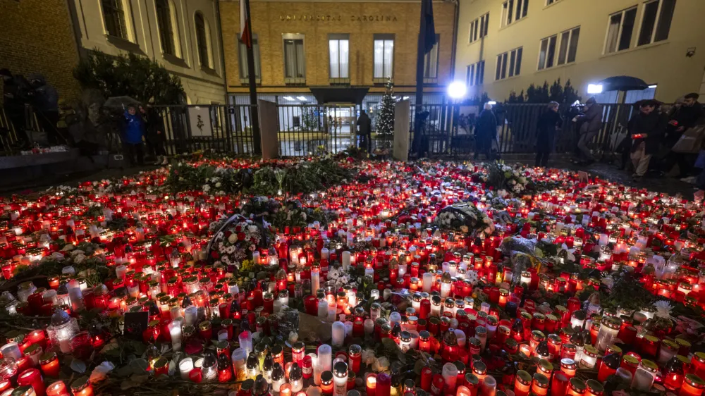 22 December 2023, Czech Republic, Prague: People light candles and place flowers at a makeshift memorial in front of the building of the Faculty of Philosophy of Charles University for the victims of the deadly shooting. On Thursday afternoon, a shooter opened fire at a university in central Prague, killing at least 14 people and injuring 25, 10 of whom were critically. Photo: Ř&iacute;hov&aacute; Michaela/CTK/dpa