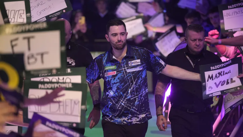 Luke Humphries of England arrives for the quarterfinal match against Dave Chisnall of England at the World Darts Championship, in London, Monday, Jan. 1, 2024. (AP Photo/Kin Cheung)