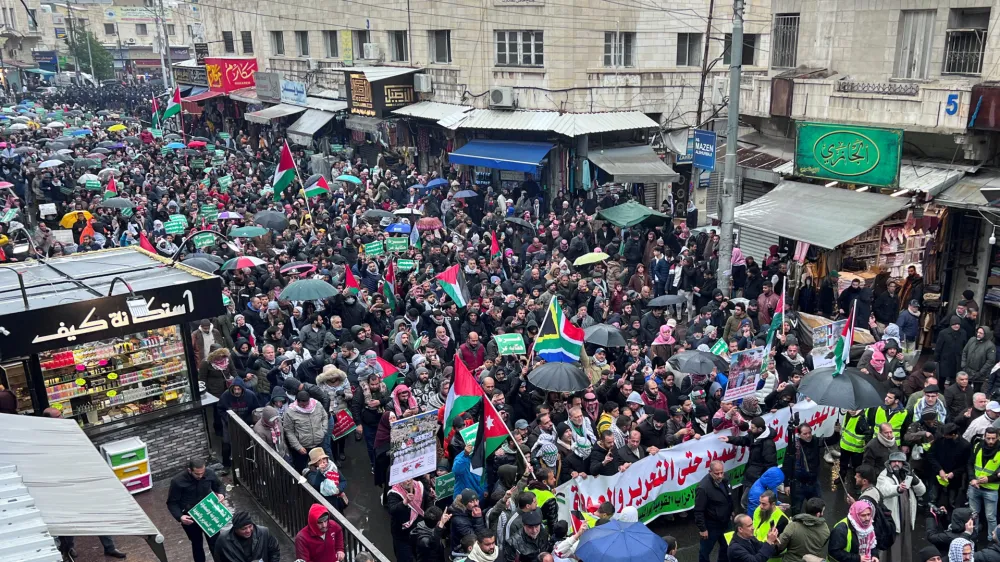 Demonstrators carry banners and flags during a protest in support of Palestinians in Gaza and to condemn strikes on Yemen, amid the ongoing conflict between Israel and the Palestinian Islamist group Hamas, in Amman, Jordan January 12, 2024. REUTERS/Jehad Shelbak