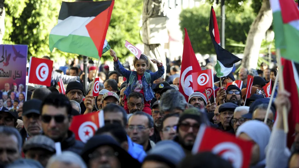 People commemorate the 13th anniversary of the Tunisian uprising in Tunis, Sunday, Jan. 14, 2024. (AP Photo/Hassene Dridi)