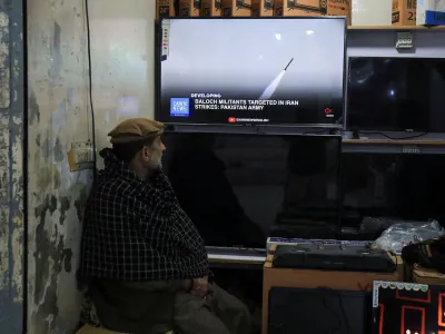 A man watches a news channel on television inside a shop after the Pakistani foreign ministry said the country conducted strikes inside Iran targeting separatist militants, two days after Tehran said it attacked Israel-linked militant bases inside Pakistani territory, in Peshawar, Pakistan January 18, 2024. REUTERS/Fayaz Aziz