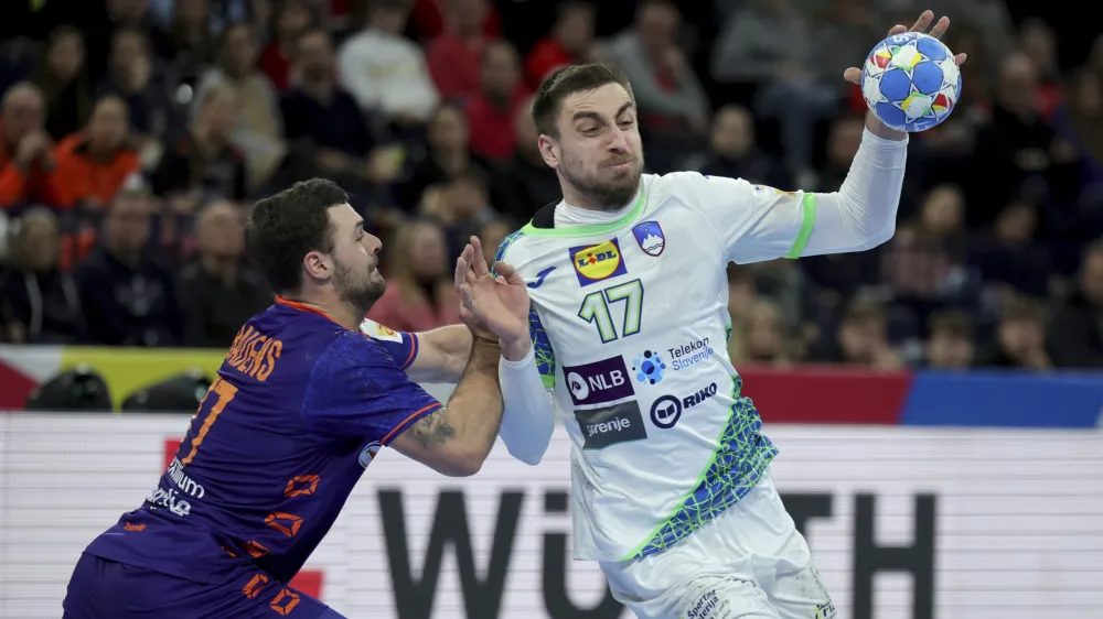 Slovenia's Nejc Cehte and Dani Baijens from the Netherlands, left, in action during the Handball European Championship main round, group 2 match between Slovenia and Netherlands in Hamburg, Germany, Sunday Jan. 21, 2024. (Christian Charisius/dpa via AP)