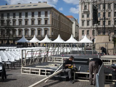 Workers set the stage in front of St. Stephen's Basilica in Budapest on Thursday, April 27, 2023 where Pope Francis will meet with bishops, priests and pastoral workers during his visit to Hungary. The spiritual priorities of Pope Francis will be on display during a trip this week to Hungary, where the populist government will seek to downplay its diverging views on matters like immigration and minority rights while focusing instead on points where it aligns with the pontiff. (AP Photo/Denes Erdos)