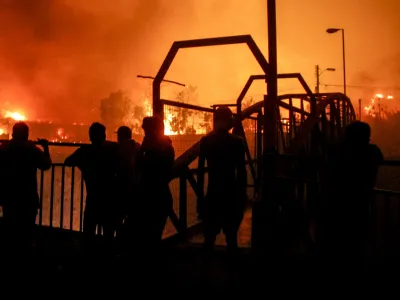Neighbors watch as a forest fire engulfs buildings in Vina del Mar, Chile, Friday, Feb. 2, 2024. (AP Photo/Cristobal Basaure)
