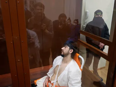 Muhammadsobir Fayzov, a suspect in the shooting attack at the Crocus City Hall concert venue, sits in a medical transport chair behind a glass wall of an enclosure for defendants before a court hearing at the Basmanny district court in Moscow, Russia March 25, 2024. REUTERS/Shamil Zhumatov