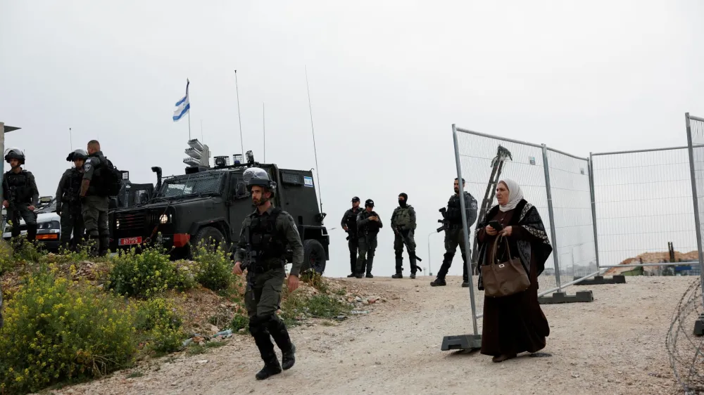 A Palestinian woman walks back from an Israeli checkpoint after she was denied entry into Jerusalem's Al-Aqsa compound, also known to Jews as the Temple Mount, to attend Friday prayers during Ramadan, at the Qalandia checkpoint in the Israeli-occupied West Bank March 29, 2024. REUTERS/Mohamad Torokman