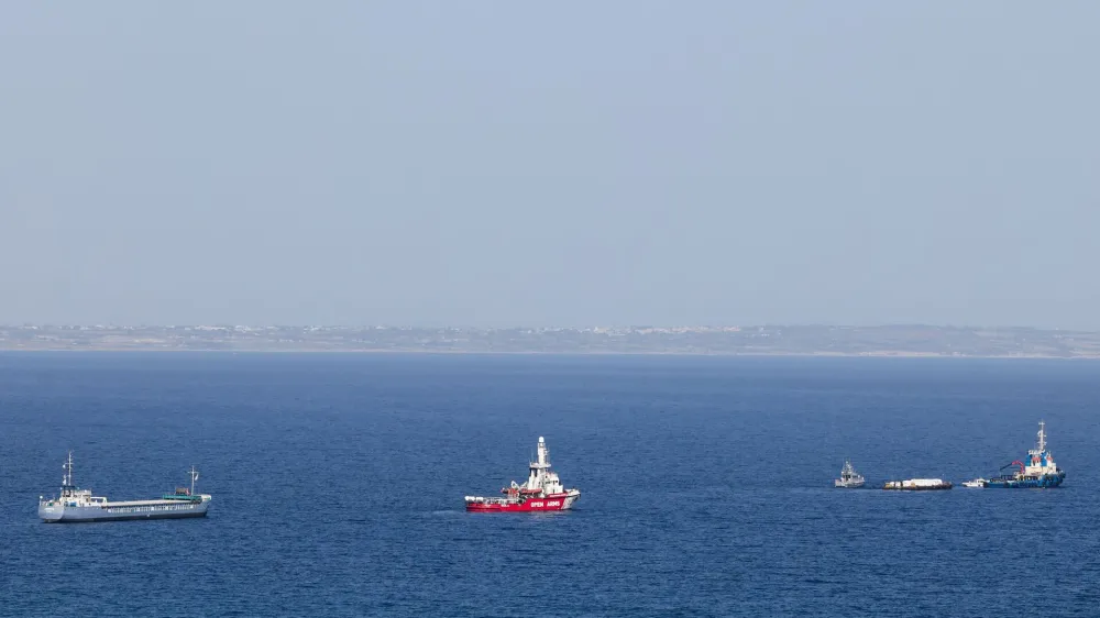 The Open Arms, a rescue vessel owned by a Spanish NGO, a cargo ship and a tug boat depart with humanitarian aid for Gaza from Larnaca, Cyprus, March 30, 2024. REUTERS/Yiannis Kourtoglou