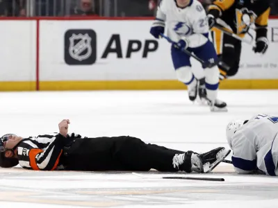 Apr 6, 2024; Pittsburgh, Pennsylvania, USA; NHL referee Steve Kozari (40) lays on the ice after an accidental collision with Tampa Bay Lightning defenseman Haydn Fleury (7) during the third period of the game against the Pittsburgh Penguins at PPG Paints Arena. The Penguins won 5-4. Mandatory Credit: Charles LeClaire-USA TODAY Sports