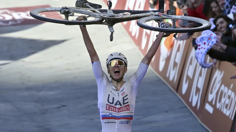 Winner Slovenia's Tadej Pogacar celebrates after crossing the finish line during the men's Strade Bianche' (White Roads) cycling race from and to Siena, Italy, Saturday, March 2, 2024. (Gian Mattia D'Alberto/LaPresse via AP)
