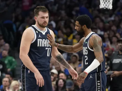 Dallas Mavericks guard Luka Doncic (77) gets a pat from teammate guard Kyrie Irving (2) during the second half of an NBA basketball game against the Los Angeles Lakers in Dallas, Sunday, Feb. 26, 2023. (AP Photo/LM Otero)