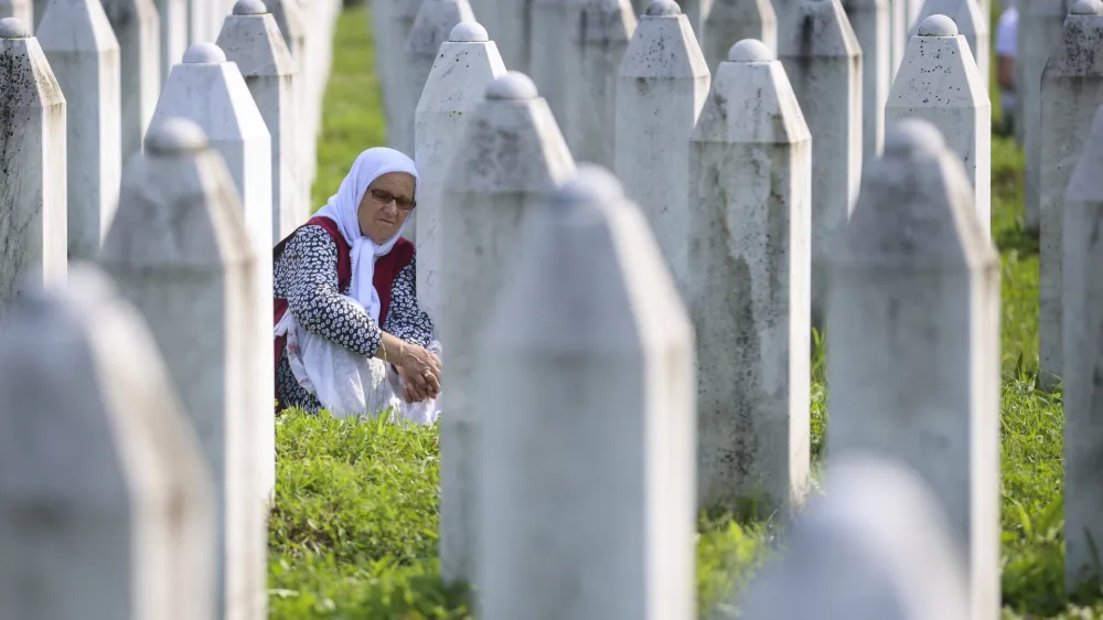 A Bosnian muslim woman mourns next to the grave of her relative, victim of the Srebrenica genocide, in Memorial Centre in Potocari, Bosnia, Tuesday, July 11, 2023. Thousands gather in the eastern Bosnian town of Srebrenica to commemorate the 28th anniversary on Monday of Europe's only acknowledged genocide since World War II. (AP Photo/Armin Durgut)