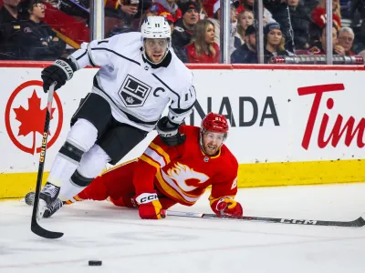Feb 27, 2024; Calgary, Alberta, CAN; Los Angeles Kings center Anze Kopitar (11) and Calgary Flames center Kevin Rooney (21) battles for the puck during the second period at Scotiabank Saddledome. Mandatory Credit: Sergei Belski-USA TODAY Sports