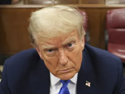 Former president Donald Trump, center, awaits the start of proceedings at Manhattan criminal court, Monday, April 22, 2024, in New York. Opening statements in Donald Trump's historic hush money trial are set to begin. Trump is accused of falsifying internal business records as part of an alleged scheme to bury stories he thought might hurt his presidential campaign in 2016. (AP Photo/Yuki Iwamura, Pool)