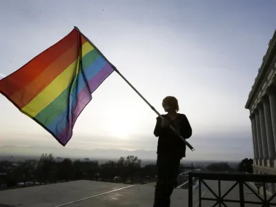 FILE - Corbin Aoyagi, a supporter of gay marriage, waves a rainbow flag during a rally at the Utah State Capitol on Jan. 28, 2014, in Salt Lake City. Utah teachers will be free to display LGBTQ+ pride flags and other social, political or religious imagery after the state House blocked a bill Monday, Feb. 26, 2024, that would have banned teachers from using their position to promote or disparage certain beliefs. (AP Photo/Rick Bowmer, File)