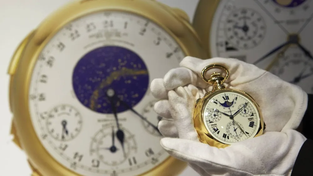 A staff member holds "The Henry Graves Supercomplication" handmade watch by Patek Philippe at Sotheby's auction house in Geneva in this November 5, 2014 file photo. A gold pocket watch made by Patek Philippe for a New York banker in the early 1930s fetched 23.2 million Swiss francs ($24 million) at auction on Tuesday, smashing the record for a timepiece it set 15 years ago, Sotheby's said. Henry Graves commissioned the famed Swiss watchmaker to produce the world's most complicated watch and surpass one made for James Packard, the American automobile manufacturer. Picture taken November 5, 2014.REUTERS/Denis Balibouse/Files (SWITZERLAND - Tags: SOCIETY BUSINESS)