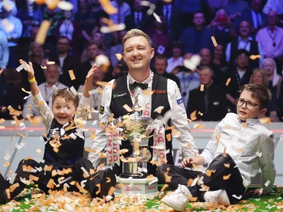 Kyren Wilson, center, celebrates with his children Finley, right, and Bailey, left, after winning the World Snooker Championship at the Crucible Theatre, Sheffield, England, Monday May 6, 2024. (Mike Egerton/PA via AP)