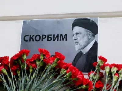 A view shows flowers outside the Iranian embassy placed to pay tribute to Iran's President Ebrahim Raisi, Foreign Minister Hossein Amirabdollahian and other victims of a recent helicopter crash in mountainous terrain near Iran's border with Azerbaijan, in Moscow, Russia, May 20, 2024. A placard with a portrait of Iran's President Ebrahim Raisi reads: "We mourn". REUTERS/Maxim Shemetov