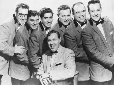 Bill Haley (sedeč v sredini) &amp; his Comets so Rock around the clock posneli leta 1954, prva rock'n'roll skladba, ki je zasedla vrh lestvice v ZDA in po svetu, pa je postala leto kasneje.