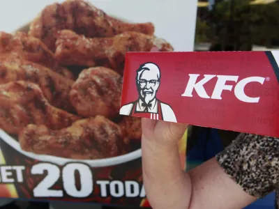 A customer holds a box of Kentucky Fried Chicken outside an KFC restaurant, Tuesday, July 13, 2010, in Mountain View, Calif. (AP Photo/Paul Sakuma)