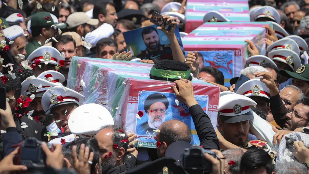 In this photo released by the Iranian Presidency Office, flag-draped coffins of the President Ebrahim Raisi and his companions who were killed in a helicopter crash on Sunday, are carried during their funeral ceremony in the city of Mashhad, Iran, Thursday, May 23, 2024. Iran on Thursday prepared to inter its late president at the holiest site for Shiite Muslims in the Islamic Republic, a final sign of respect for a prot&eacute;g&eacute; of Iran's supreme leader killed in a helicopter crash earlier this week. (Iranian Presidency Office via AP)