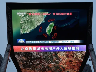 A large screen shows news footage of a map of military drills conducted by the Eastern Theatre Command of the Chinese People's Liberation Army (PLA) in five areas around the island of Taiwan, in Beijing, China May 23, 2024. REUTERS/Tingshu Wang