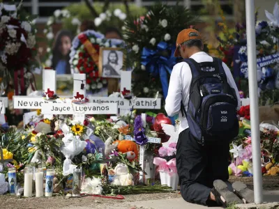 A man kneels at a memorial outside Robb Elementary School to honor the victims killed in a school shooting in Uvalde, Texas Sunday, May 29, 2022. (AP Photo/Dario Lopez-Mills)