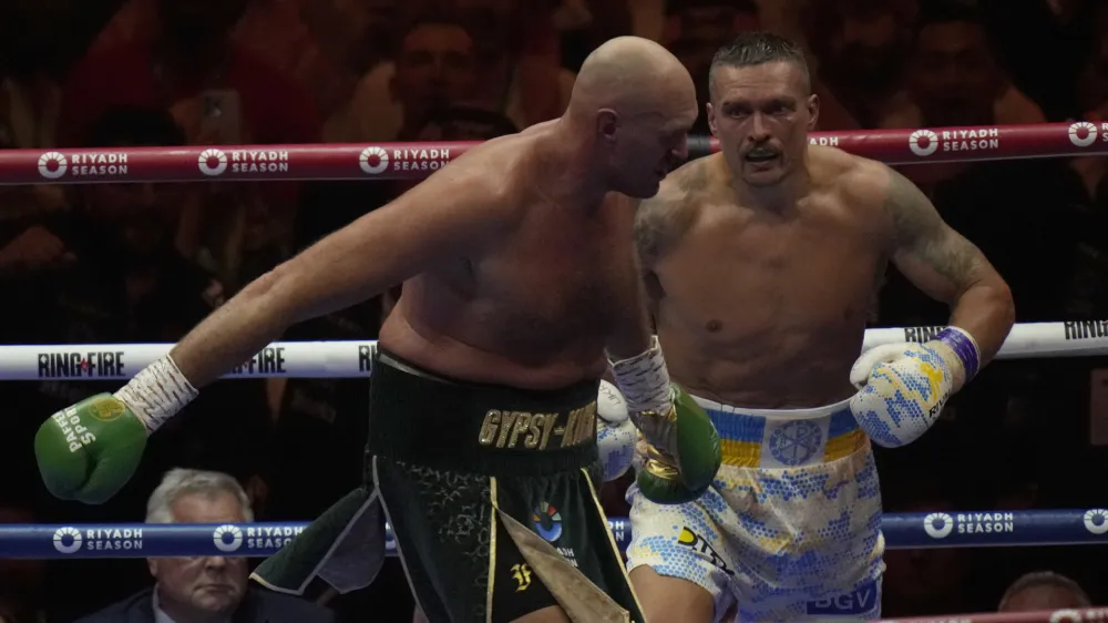 Ukraine's Oleksandr Usyk, right, pursues Britain's Tyson Fury during their undisputed heavyweight world championship boxing fight at the Kingdom Arena in Riyadh, Saudi Arabia, Sunday, May 19, 2024. (AP Photo/Francisco Seco)