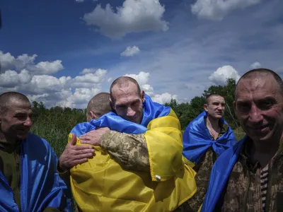 A Ukrainian serviceman hugs his comrade after returning from captivity during a POWs exchange in Sumy region, Ukraine, Friday, May 31, 2024. Ukraine returned 75 prisoners, including four civilians, in the latest exchange of POWs with Russia. It's the fourth prisoner swap this year, and 52nd since Russia invaded Ukraine. In all, 3 210 Ukrainian servicemen and civilians were returned since the outbreak of the war. (AP Photo/Evgeniy Maloletka)
