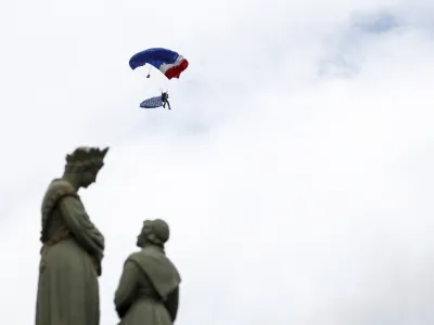 A French soldier of the 1st RPIMa Special Forces parachutes during a ceremony to pay homage to the Saint Marcel maquis, a force of French Resistance fighters during World War II and the French SAS (Special Air Service) paratroopers, in Plumelec, Brittany, on the eve of D-Day 80th anniversary landings in Normandy, Wednesday June 5, 2024. (Benoit Tessier/Pool via AP)