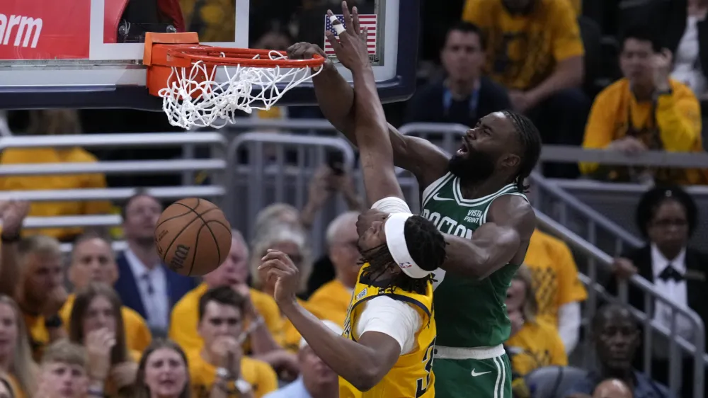 Boston Celtics guard Jaylen Brown, right, dunks the ball over Indiana Pacers center Myles Turner during the second half of Game 3 of the NBA Eastern Conference basketball finals, Saturday, May 25, 2024, in Indianapolis. (AP Photo/Darron Cummings)
