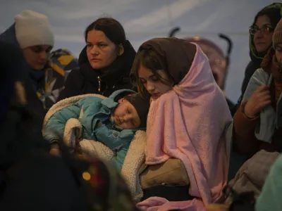 Refugees, mostly women with children, rest inside a tent after arriving at the border crossing, in Medyka, Poland on Sunday, March 6, 2022. (AP Photo/Visar Kryeziu)