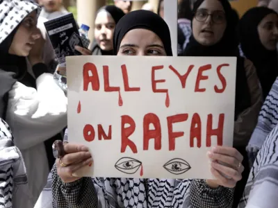 FILE - A student holds a placard as she chants slogans during a protest inside the American University of Beirut to show support for Palestinians in the Gaza Strip, in Beirut, Lebanon, Tuesday, May 7, 2024. A single image, not even an authentic photograph, is the focus of a singular campaign on Instagram that has caught the attention of the algorithm and captured the imaginations of users across national borders &mdash; a show of support for the Palestinian movement as the war between Israel and Hamas enters its eighth month. (AP Photo/Bilal Hussein, File)