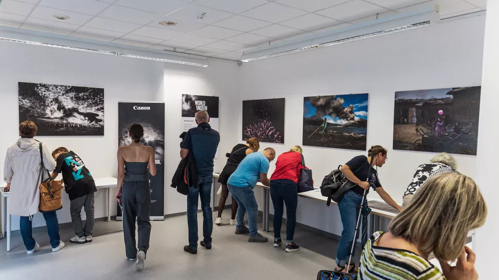 Na razstavi so prilagojene fotografije Brenta Stirtona, Sebasti&atilde;a Salgada, Muhammeda Muheisena in slovenskega fotografa Sama Vidica.&nbsp;