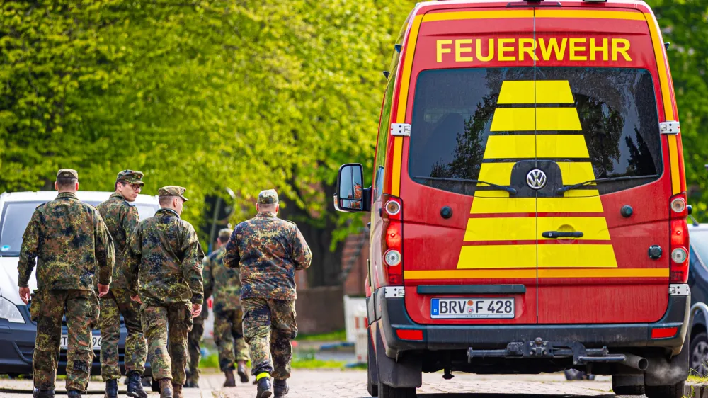 FILED - 27 April 2024, Lower Saxony, Elm: Soldiers of the German Armed Forces walk along a street in a residential area, past a fire department vehicle during the search operation for Arian a missing six-year-old child in northern Lower Saxony. A body found in the German state of Lower Saxony was on 27 June confirmed as that of Arian's, police said.There were no indications of foul play, investigators said. They&nbsp;did not reveal the cause of death to protect the family. Photo: Moritz Frankenberg/dpa