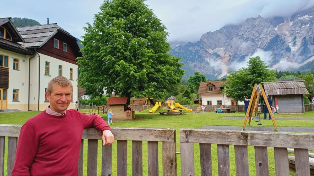 Župan Andrej Karničar ob velikem ograjenem igri&scaron;ču, kjer se v lepem vremenu najraje družijo učenci z Jezerskega.