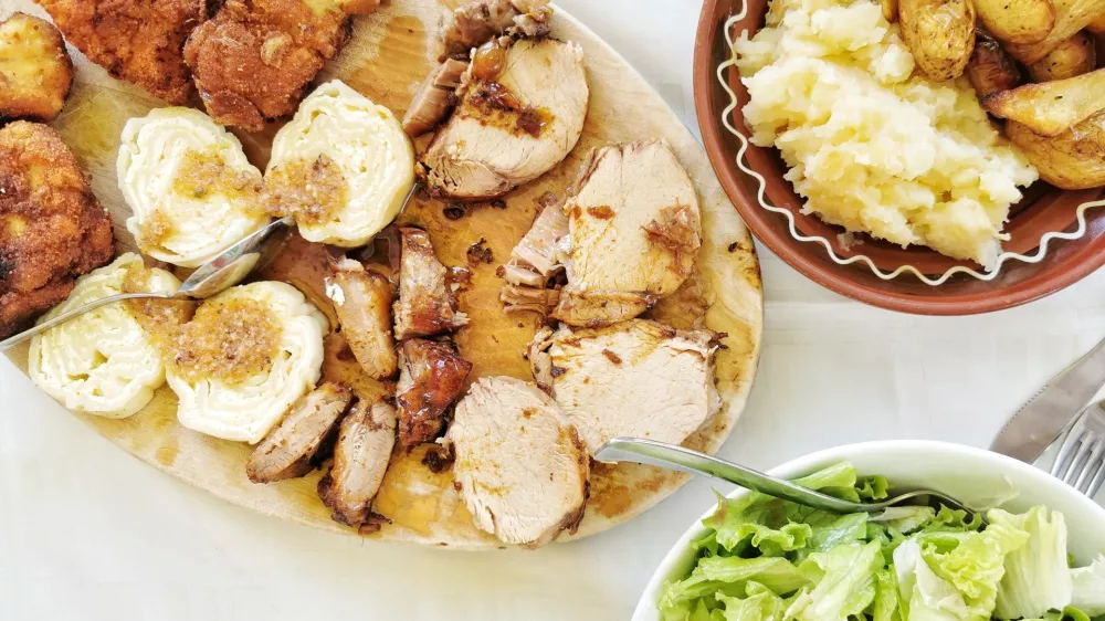 Pohana pi&scaron;ka, svinjski kare in priloge / Foto: Miha First