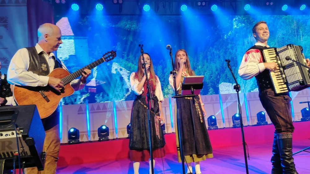 Ansambel Sa&scaron;a Avsenika na odru festivala z gostoma Gregorjem Avsenikom na kitari in Moniko Avsenik za mikrofonom. / Foto: Mojca Marot