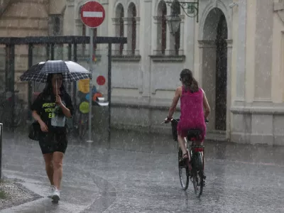 - 19.06.2019 &ndash; ljubljanski utrinek - kolesarka v dežju, nevihta - ploha -dež//FOTO: Luka Cjuha.