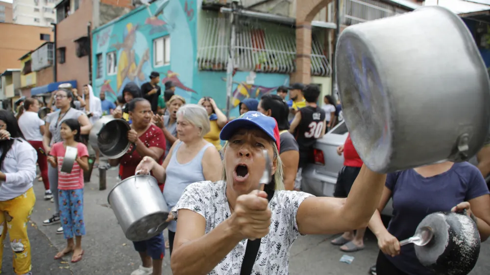 Residents bang pots to protest the day after the presidential election in Caracas, Venezuela, Monday, July 29, 2024. (AP Photo/Cristian Hernandez)