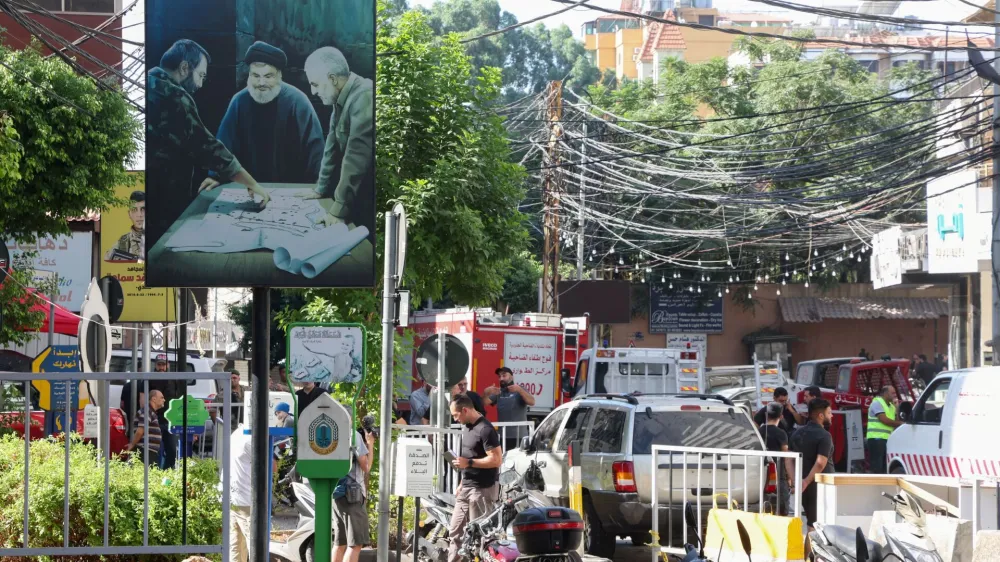 A poster depicting Lebanon's Hezbollah leader Sayyed Hassan Nasrallah, late top commander of Iran's Quds Force Qassem Soleimani and the late Hezbollah military commander Imad Moughniyeh, is pictured near a damaged site, the day after an Israeli strike, in Beirut's southern suburbs, Lebanon July 31, 2024. REUTERS/Mohamed Azakir