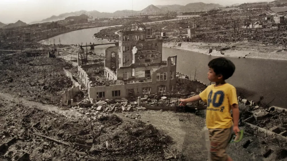 A boy looks at a huge photograph showing Hiroshima city after the 1945 atomic bombing, at the Hiroshima Peace Memorial Museum, Japan August 6, 2007. Japan marked the 62nd anniversary of Hiroshima's atomic bombing with a solemn ceremony on Monday as the city's mayor criticised the United States for refusing to give up its nuclear weapons programme. REUTERS/Toru Hanai (JAPAN)