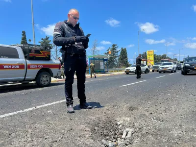 An Israeli policeman inspects the impact site of a projectile, after Lebanon's armed group Hezbollah said it launched a swarm of attack drones against military targets in northern Israel, in Nahariya, northern Israel, August 6, 2024. REUTERS/Avi Ohayon