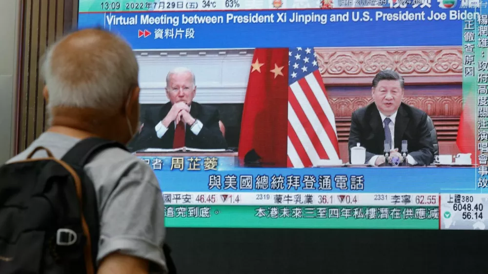 A screen displays images of Chinese President Xi Jinping and U.S. President Joe&nbsp;Biden, while broadcasting news about their recent call at a shopping mall in Hong Kong, China, July 29, 2022. REUTERS/Tyrone Siu