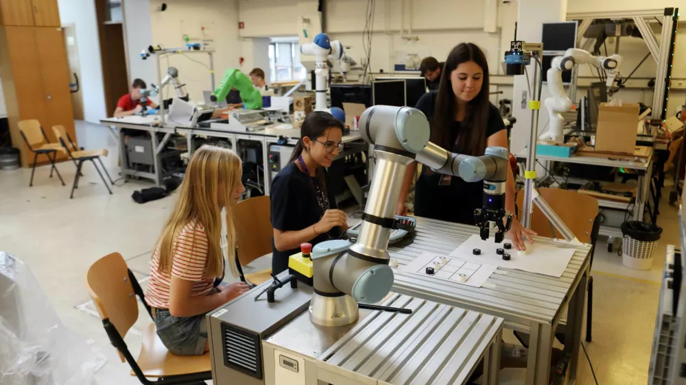 Skupina deklet z robotom igra igro križcev in krožcev. Foto:&nbsp;Tomaž Skale