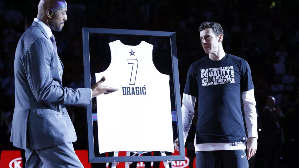 Alonzo Mourning, left, Miami Heat vice president of player programs, presents guard Goran Dragic his NBA All-Star Game jersey during a ceremony before the start of an NBA basketball game against the Houston Rockets, Wednesday, Feb. 7, 2018, in Miami. Dragic will replace injured Kevin Love in 2018 NBA All-Star Game. (AP Photo/Wilfredo Lee)