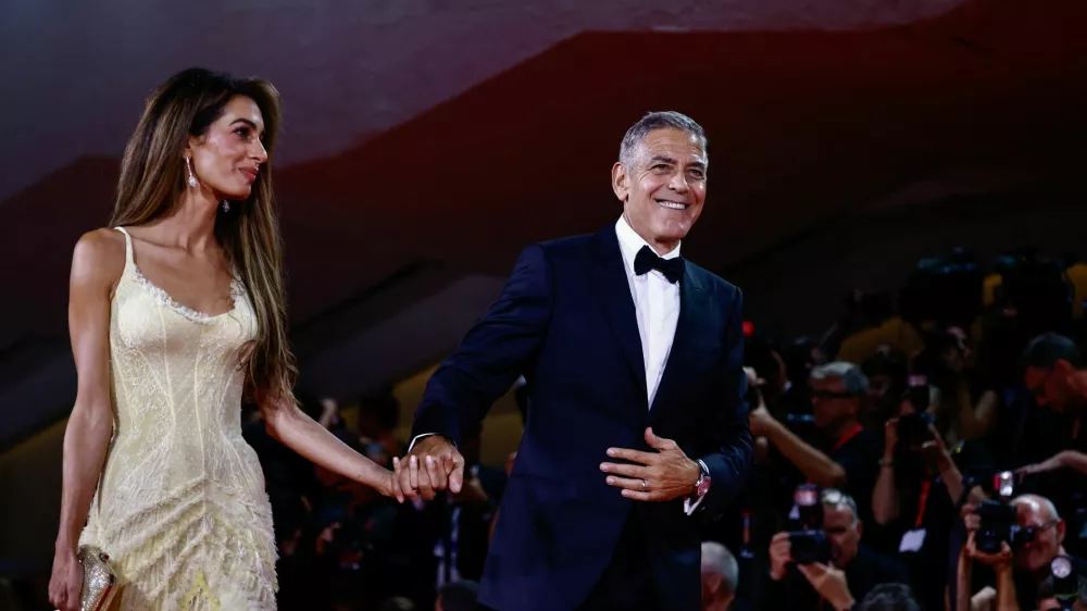 George Clooney and Amal Clooney walk on the red carpet during arrivals the movie "Wolfs" presented out of competition, during the 81st Venice Film Festival, in Venice, Italy, September 1, 2024. REUTERS/Yara Nardi