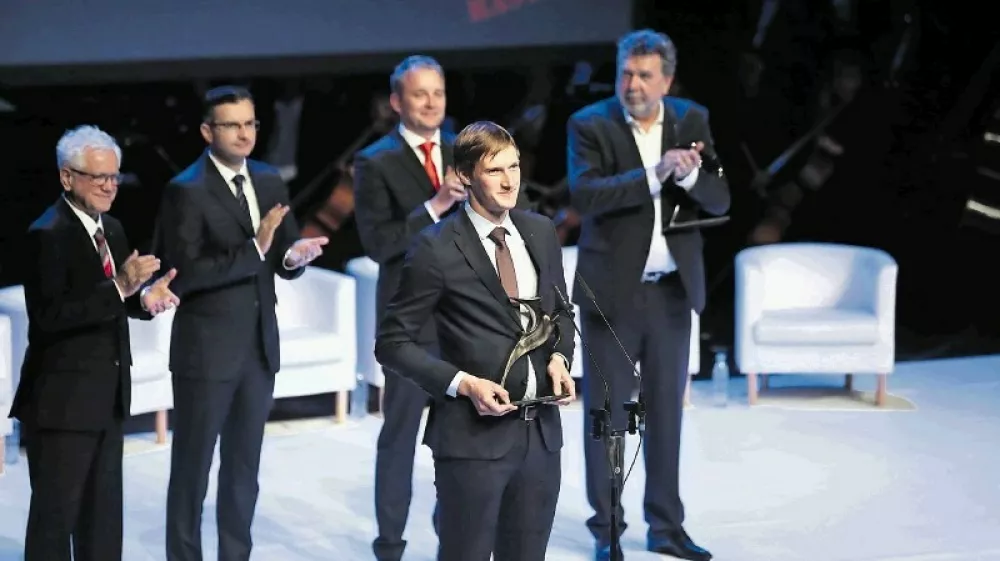 Priznanje zlata gazela 2018 je prevzel Simon Mesec iz Meborja. V ozadju so &scaron;e (z leve) predsednik Sveta Gazela Mirko Stra&scaron;ek, predsednik vlade Marjan &Scaron;arec ter tretje- in drugouvr&scaron;čeni Robert Medle iz bronaste gazele Roletarstvo Medle in Marino Furlan iz srebrne gazele Intra lighting.