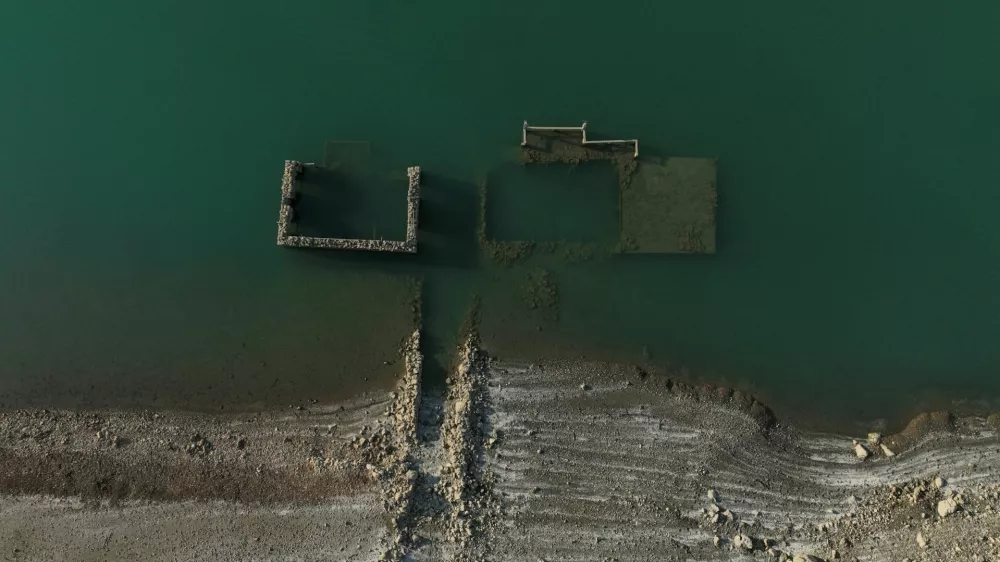 A drone view shows the reappearing remains of buildings of the village of Kallio, which was intentionally flooded in 1980 to create a reservoir that would help meet the water needs of Greek capital Athens, following receding water levels caused by drought, in Lake Mornos, Greece, September 3, 2024. REUTERS/Stelios Misinas