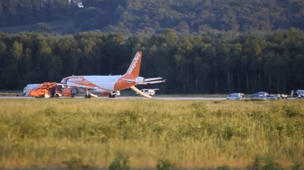 In this June 10, 2017 photo taken from video, a EasyJet plane stands at Cologne-Bonn airport, in Cologne Germany. German police are questioning three British citizens after their conversation during a flight to London prompted an EasyJet pilot to make an unscheduled stop in Cologne late Saturday. A spokesman for Cologne police says other passengers on the flight from the Slovenian capital Ljubljana overheard a conversation with "terrorist content" between the men, aged 31, 38 and 48. Airport authorities said in a statement that the 151 passengers on board disembarked the plane using emergency slides. (Thomas Kraus/dpa via AP)